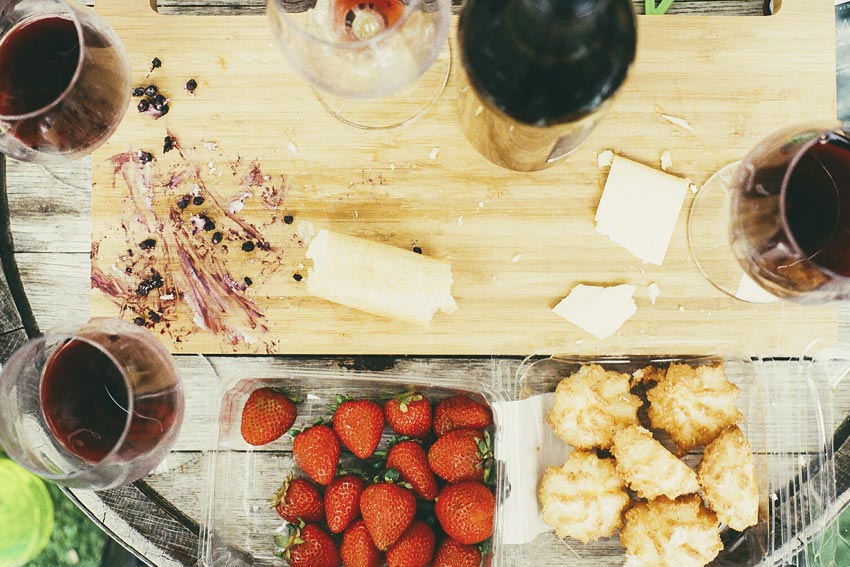 Wein und ein Schneidbrett mit Erdbeeren und Käse