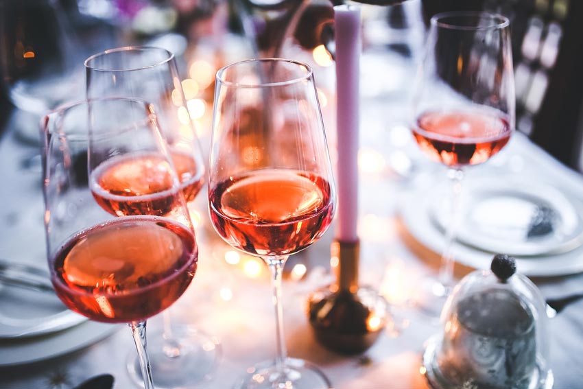 Gläser mit Roséwein auf einem gedeckten Tisch