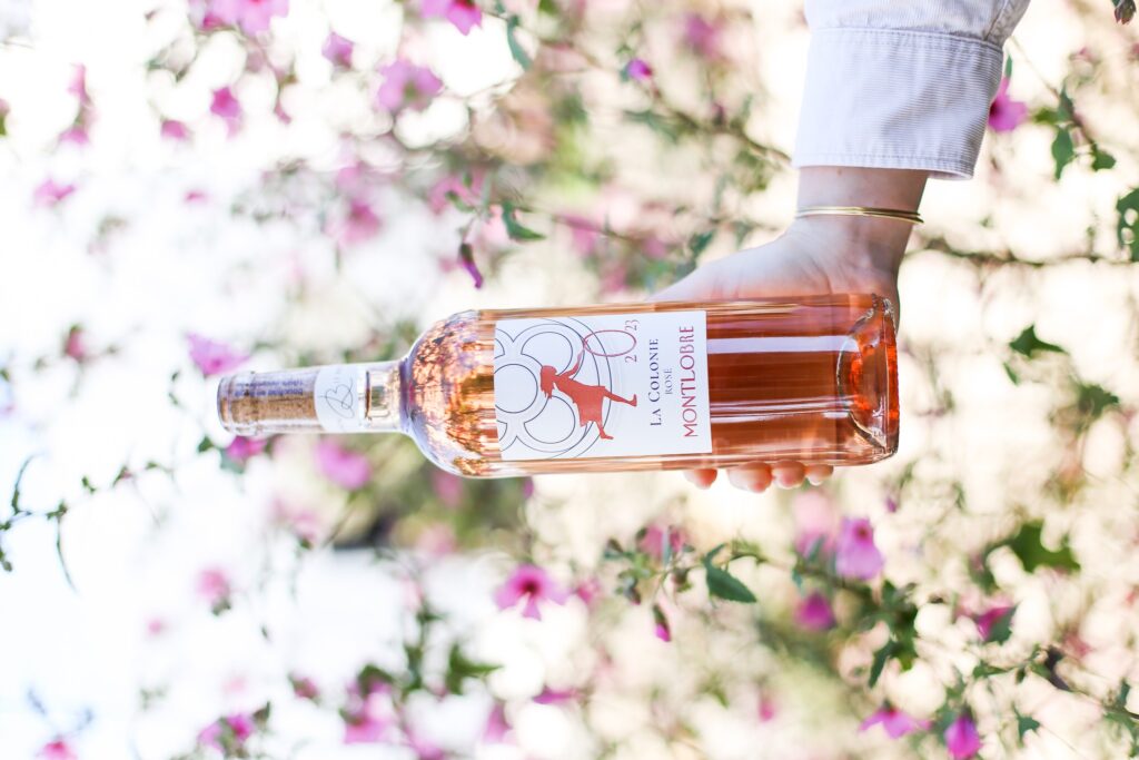 Eine weibliche Hand mit einer Flasche Roséwein von Montlobre