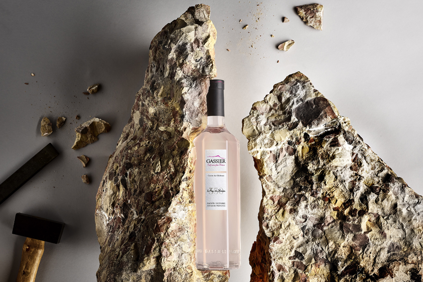 eine Flasche Rose von der Maison Gassier, dahinter Steinbrocken