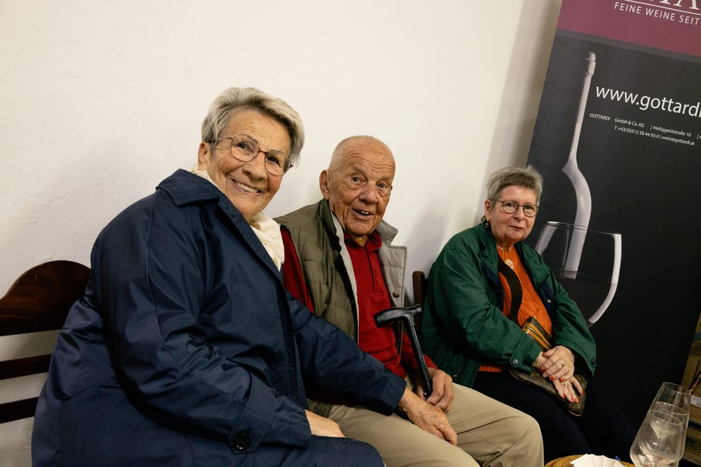 Zwei ältere Frauen und ein älterer Mann mit Gehstock